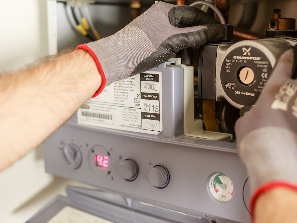 Plumber repairing a water heater to ensure efficient hot water supply